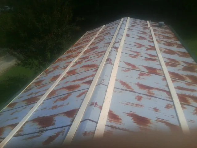Rusted metal roof panels with new wood purlins before replacement — Storm Damage Roof Repair in Elizabeth by Roofing Brothers